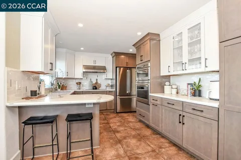 a kitchen with white cabinets and stainless steel appliances
