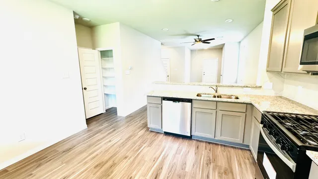 a view of a room with wooden floor and a ceiling fan