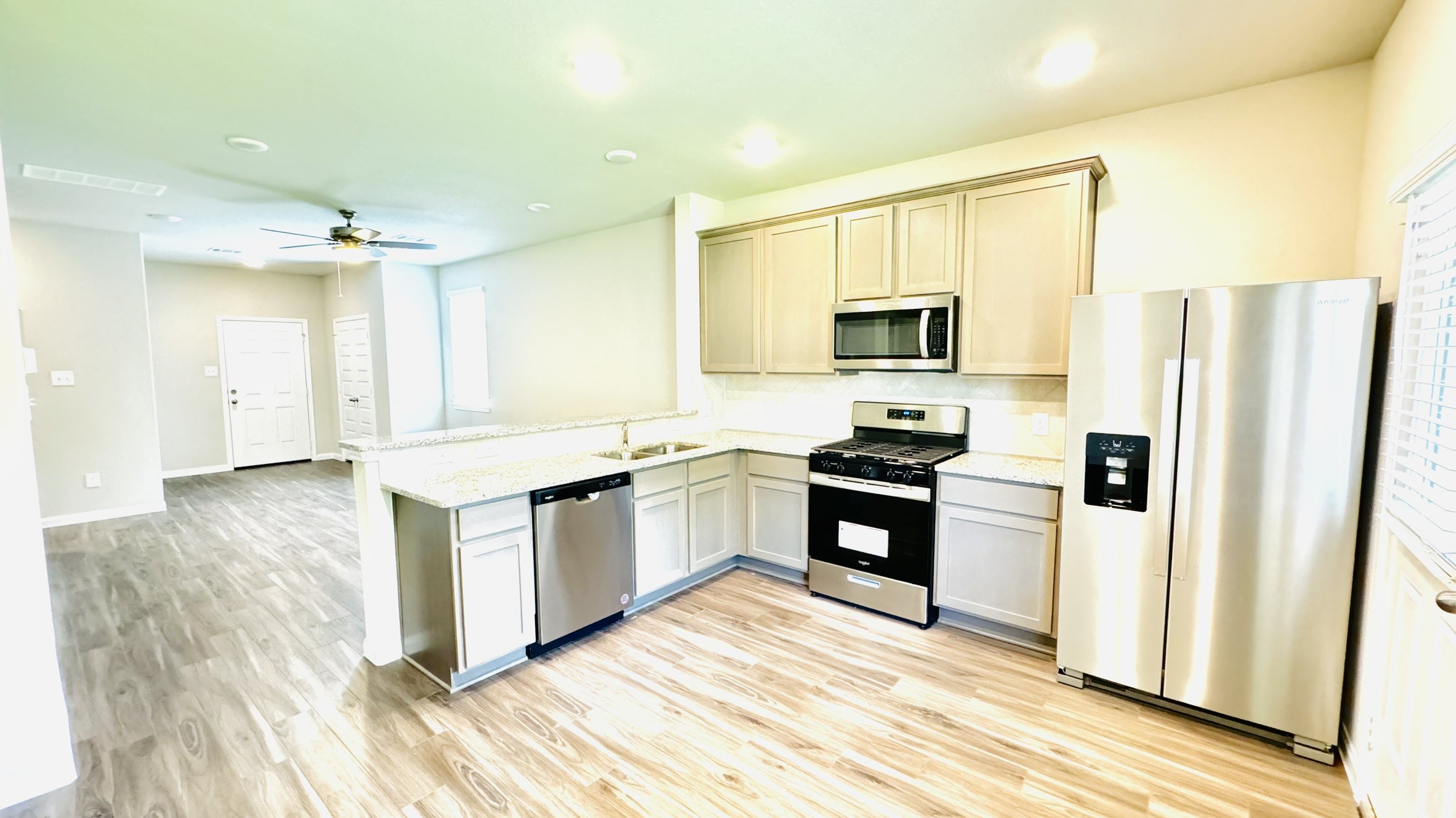 2423 Bluefish Court Conroe, TX 77384 - Photo 23 of 30 a kitchen with granite countertop a refrigerator stove top oven and sink