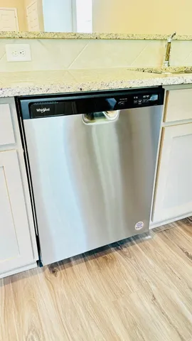 a view of a refrigerator in kitchen with stainless steel appliances wooden floor