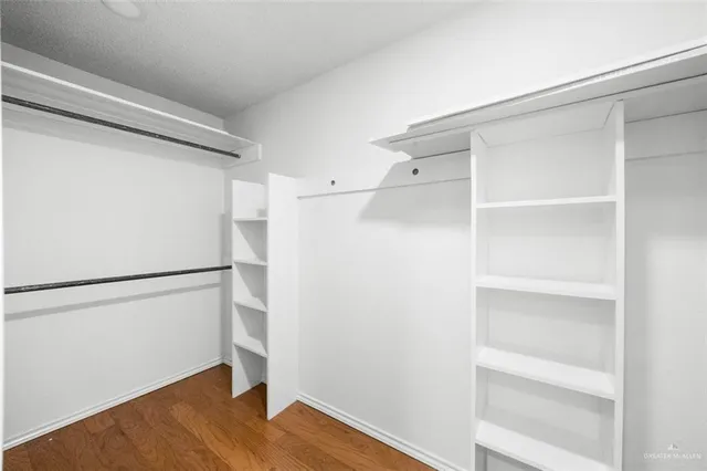 a view of walk in closet with empty racks