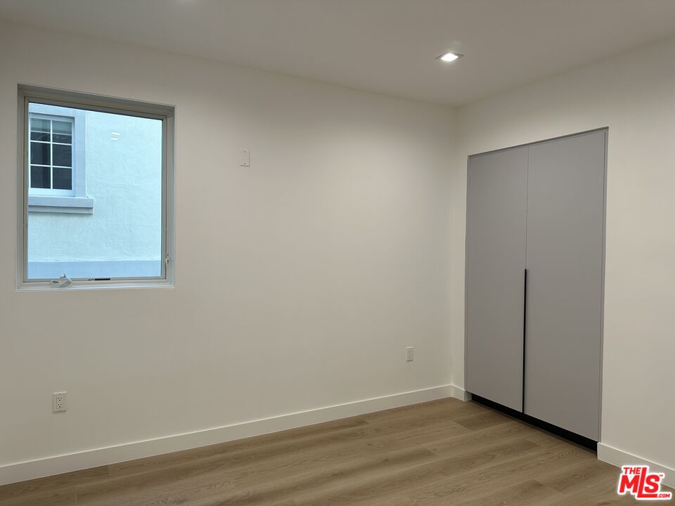 9842 Vidor Drive, Unit 201 Los Angeles, CA 90035 - Photo 12 of 20 a view of an empty room with wooden floor and a window