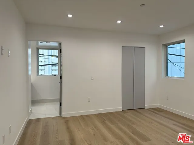 an empty room with closet and windows