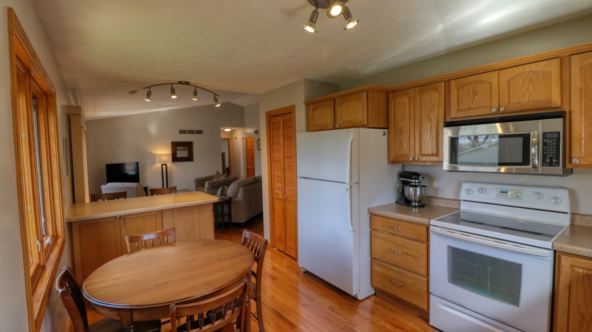 23 Cedar Court Bloomington, IL 61701 - Photo 10 of 36 a kitchen with a refrigerator a stove microwave oven a sink dishwasher with a dining table and chairs with wooden floor