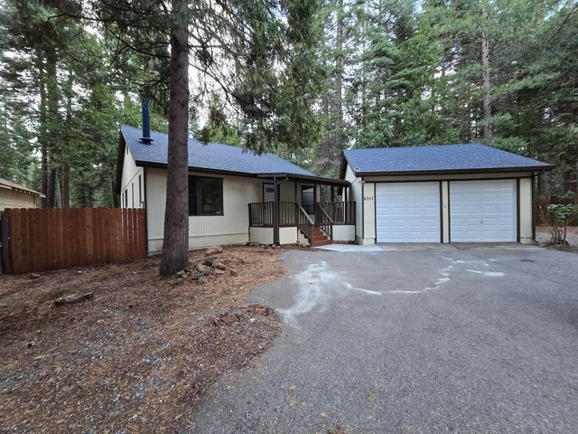 a view of a house with a yard and tree