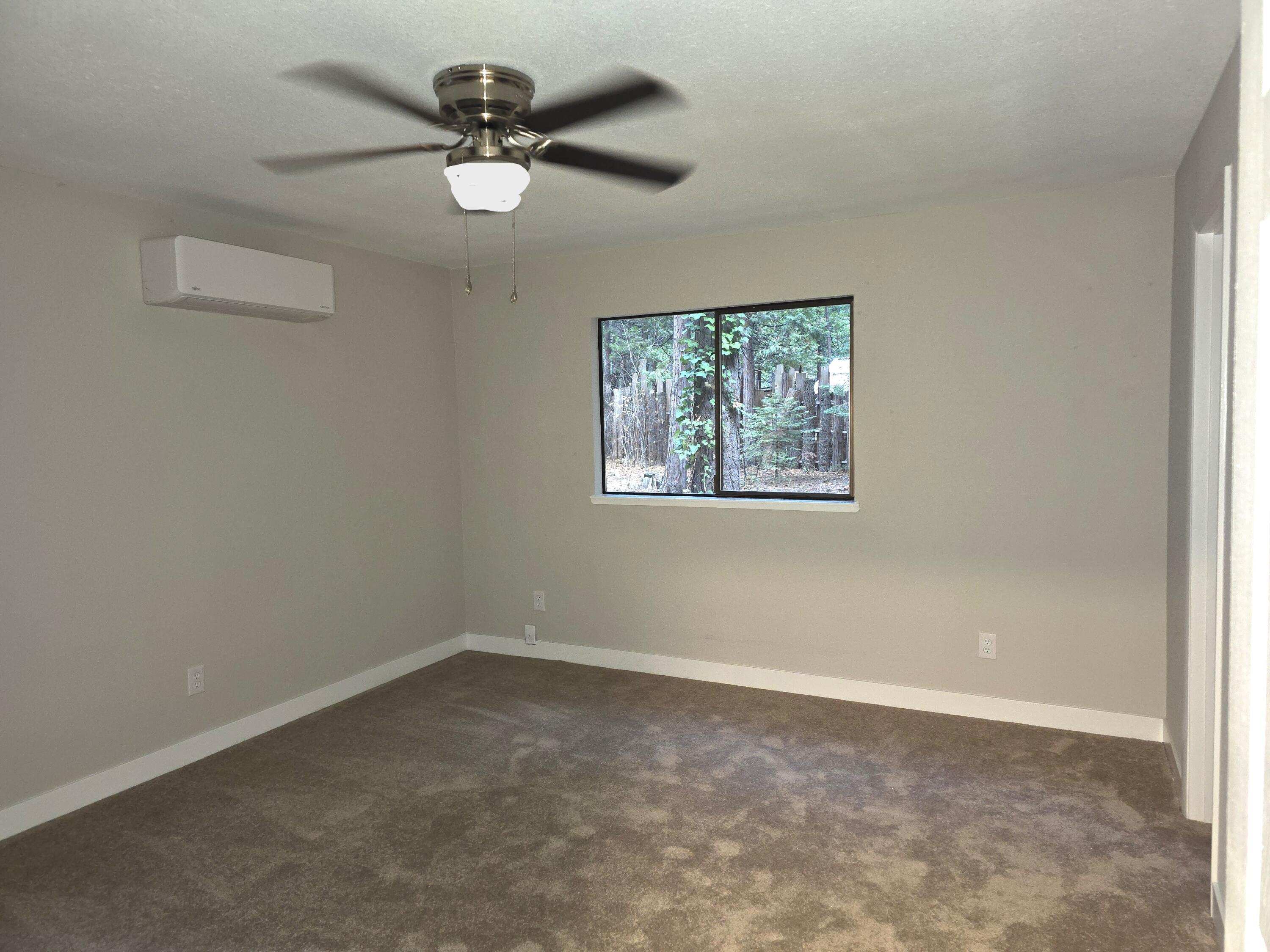 8353 Starlite Pines Road Shingletown, CA 96088 - Photo 12 of 30 an empty room with windows and ceiling fan