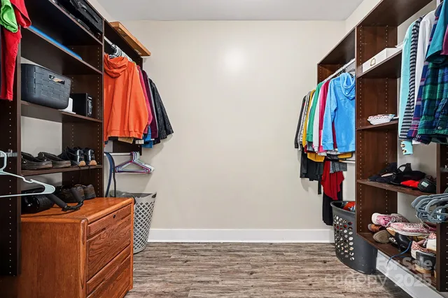 a view of walk in closet with clothes and shoes