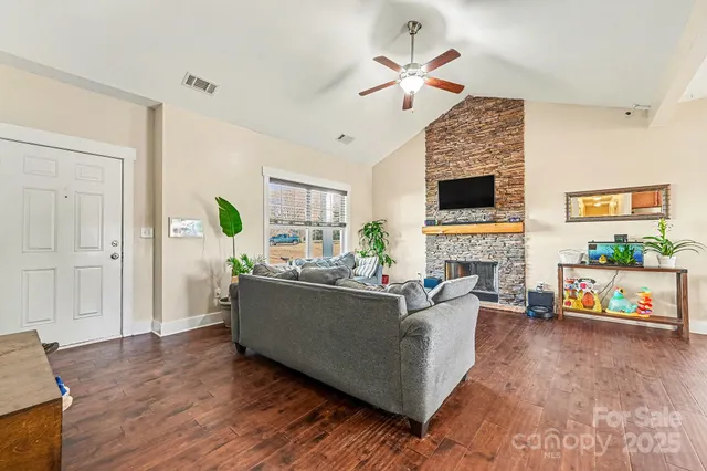 a living room with furniture a fireplace and a flat screen tv