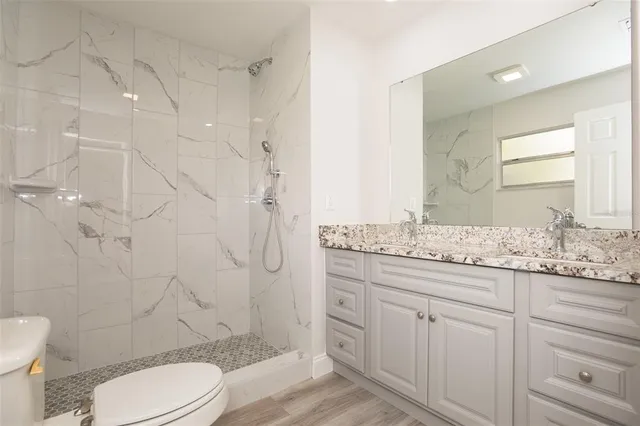 a bathroom with a granite countertop toilet sink and shower