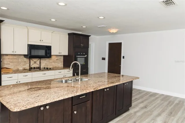 a kitchen with granite countertop a sink and a refrigerator