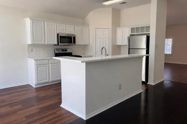 a kitchen with stainless steel appliances a microwave a sink and cabinets