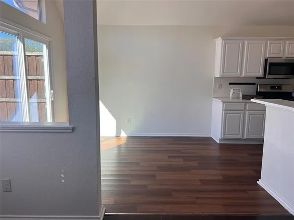 a view of a kitchen with wooden floor and electronic appliances