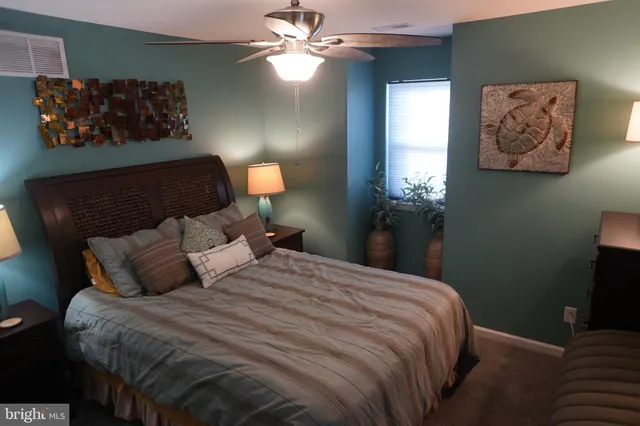 a bedroom with a bed and a painting on the wall