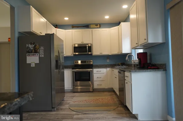 a kitchen with stainless steel appliances granite countertop a refrigerator and a stove top oven