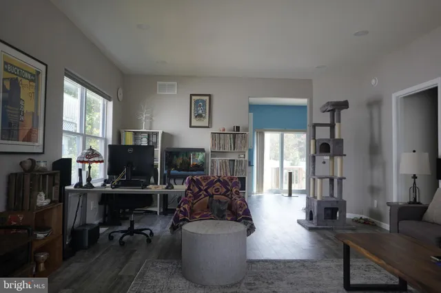 a living room with furniture a flat screen tv and a window