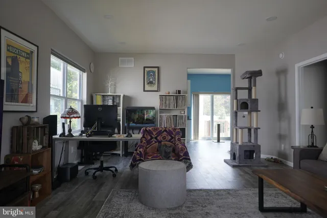 a living room with furniture a flat screen tv and a window
