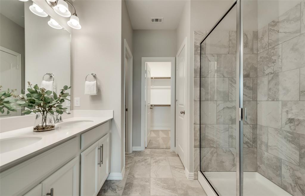 1608 Kendell Street Anna, TX 75409 - Photo 19 of 28 a bathroom with a sink a large mirror and a shower