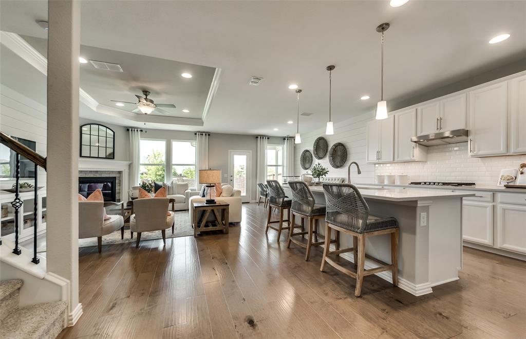 1608 Kendell Street Anna, TX 75409 - Photo 8 of 28 a open kitchen with stainless steel appliances granite countertop a stove top oven a sink dishwasher a dining table and chairs with wooden floor