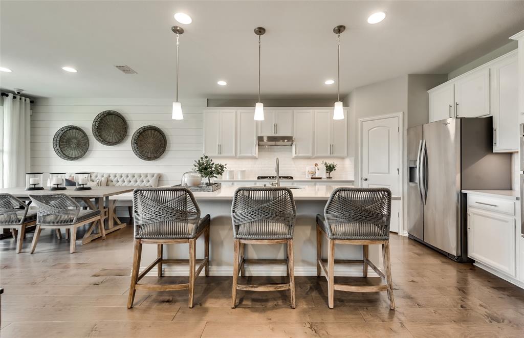 1608 Kendell Street Anna, TX 75409 - Photo 10 of 28 a kitchen with a dining table chairs and a refrigerator