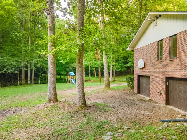 an empty room with windows and a ceiling fan