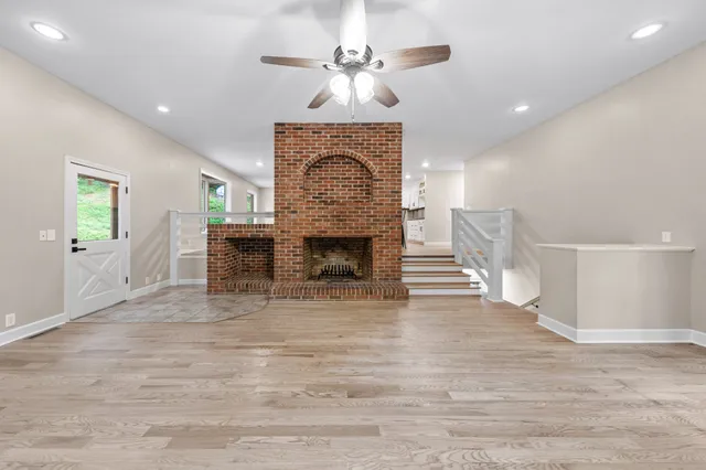 a view of a kitchen with dining space wooden floor electric appliances and windows