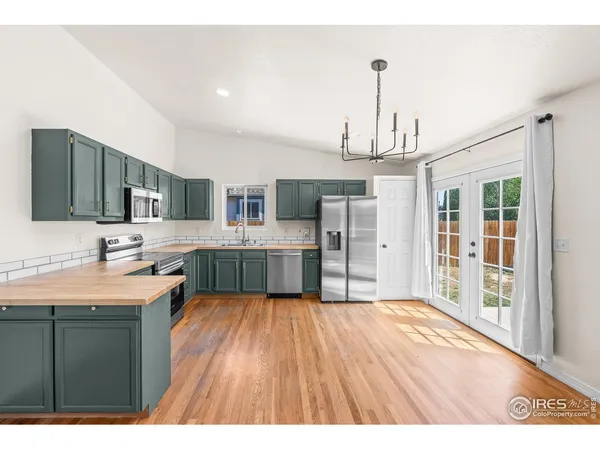 a kitchen with stainless steel appliances granite countertop a sink refrigerator and cabinets