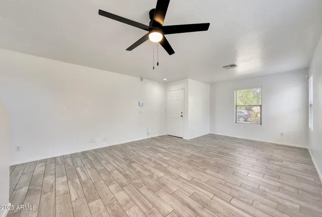 a view of empty room with wooden floor
