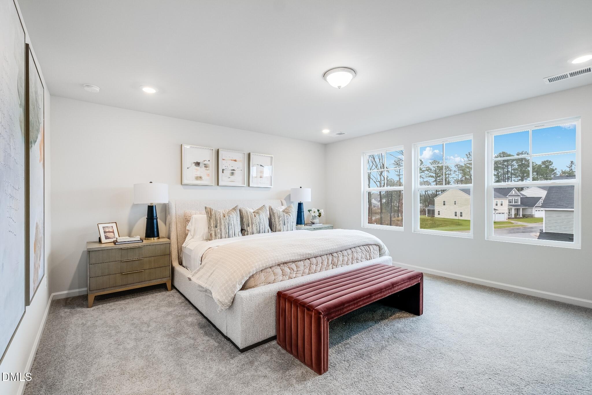 1028 Red Finch Way Angier, NC 27501 - Photo 26 of 40 a spacious bedroom with a bed and a large window