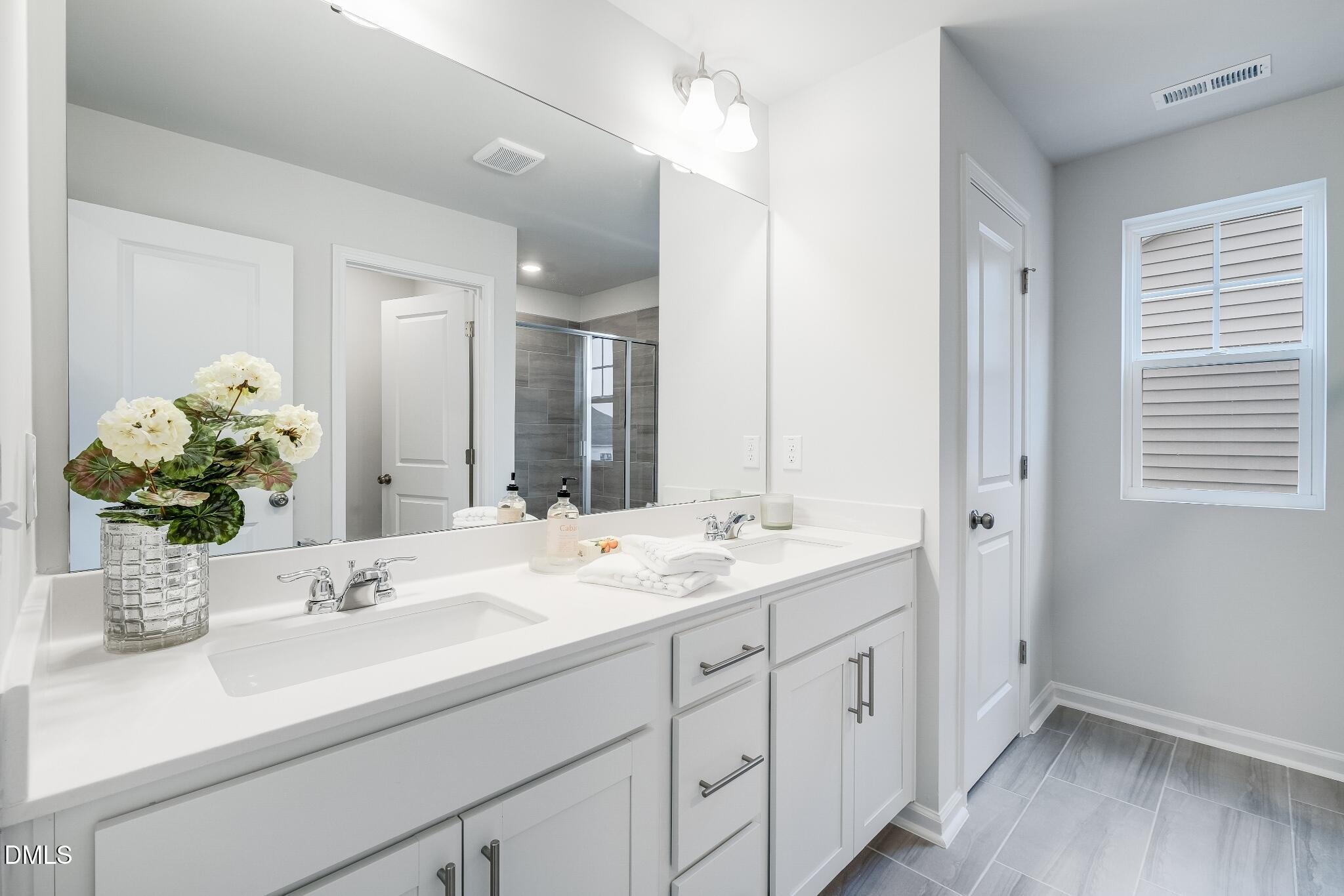 1028 Red Finch Way Angier, NC 27501 - Photo 32 of 40 a bathroom with a sink double vanity granite and a mirror