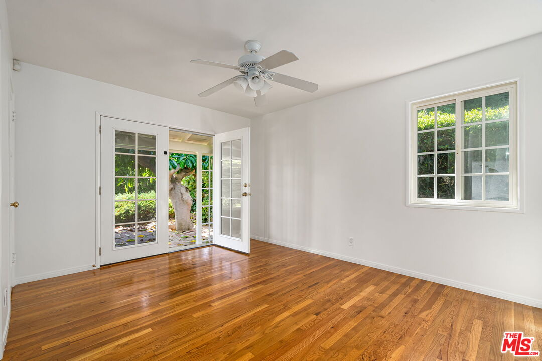 3919 South Ridgeley Drive Los Angeles, CA 90008 - Photo 13 of 23 a view of an empty room with wooden floor and a window