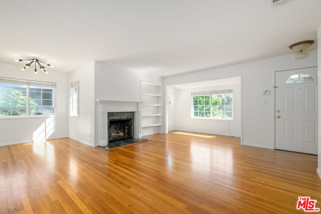 3919 South Ridgeley Drive Los Angeles, CA 90008 - Photo 7 of 23 a view of an empty room with wooden floor and a window