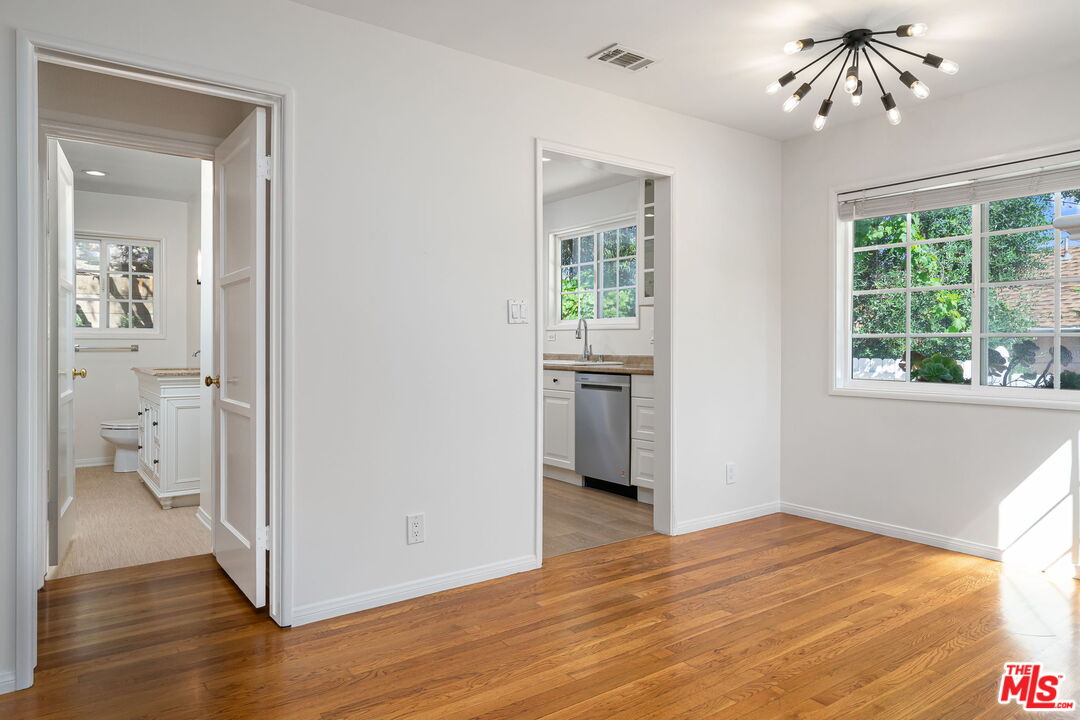 3919 South Ridgeley Drive Los Angeles, CA 90008 - Photo 9 of 23 a view of a room with wooden floor electronic appliances and windows