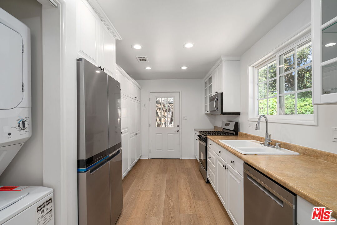 3919 South Ridgeley Drive Los Angeles, CA 90008 - Photo 10 of 23 a kitchen with a sink stove and refrigerator