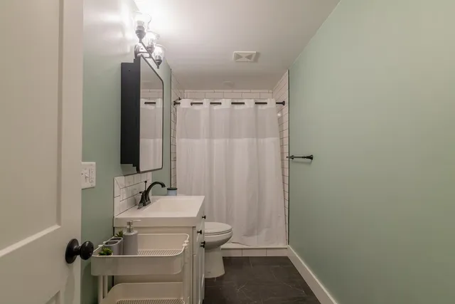 a bathroom with a sink a toilet and shower