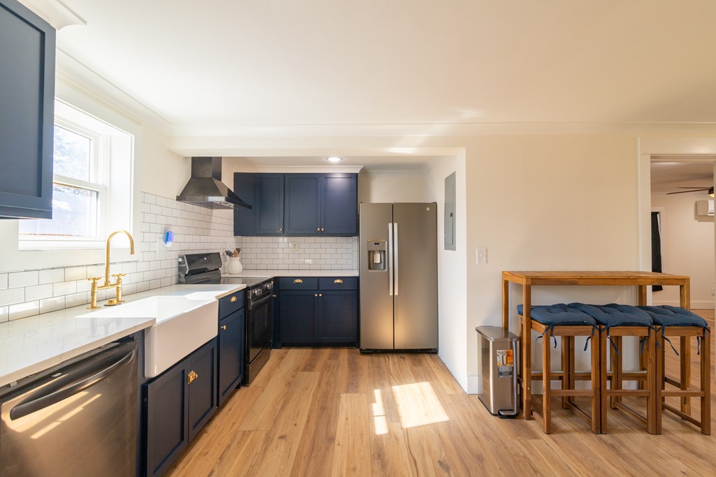 1519 1/2 16th Avenue Columbus, GA 31901 - Photo 7 of 25 a kitchen with stainless steel appliances granite countertop a refrigerator a sink dishwasher a stove and white countertops with wooden floor