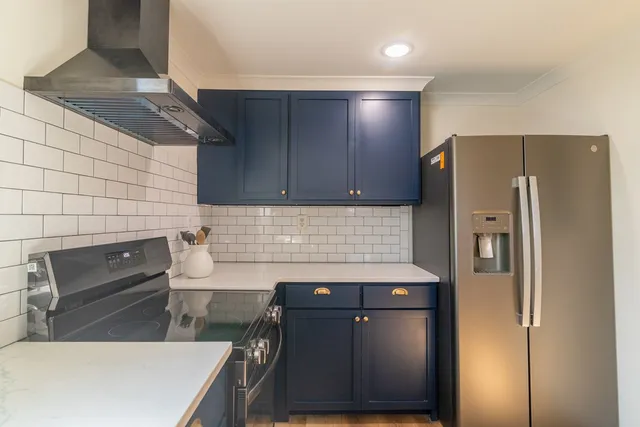 a kitchen with stainless steel appliances granite countertop a refrigerator and a stove