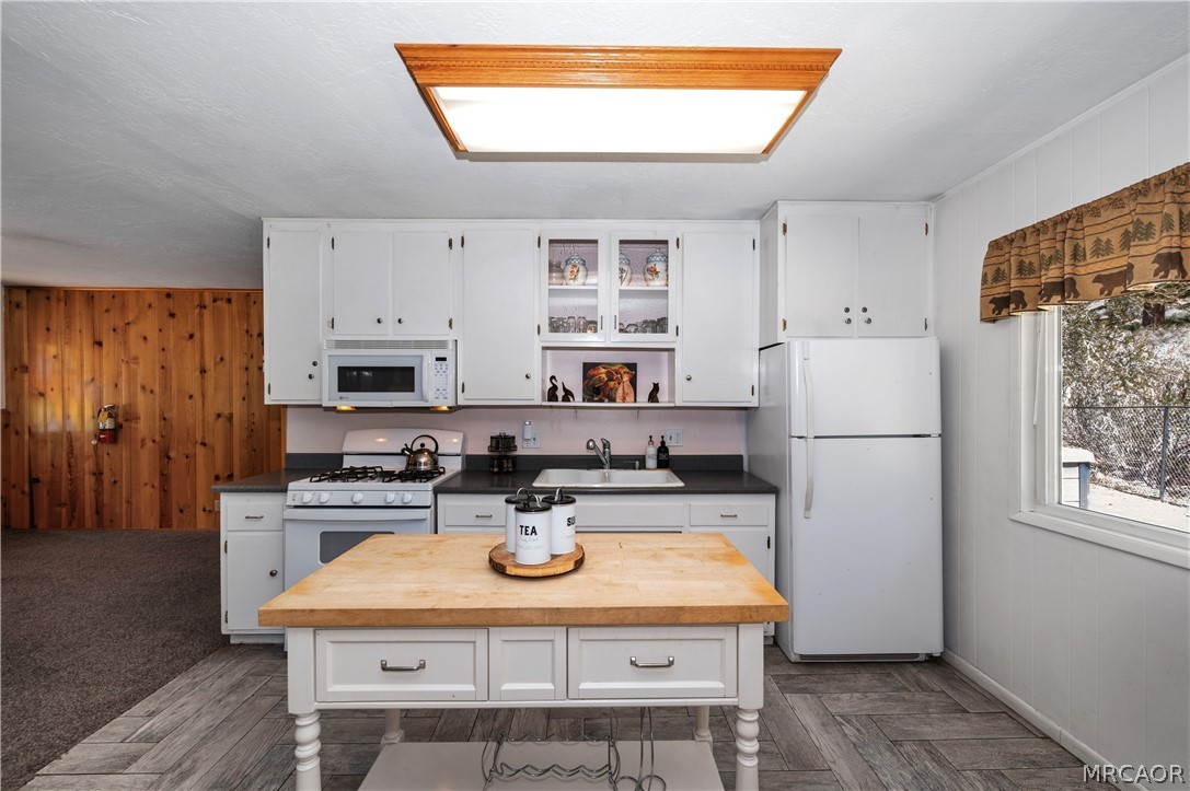 1099 Canyon Road Fawnskin, CA 92333 - Photo 15 of 39 a kitchen with stainless steel appliances granite countertop a refrigerator a stove a sink dishwasher and white cabinets with wooden floor