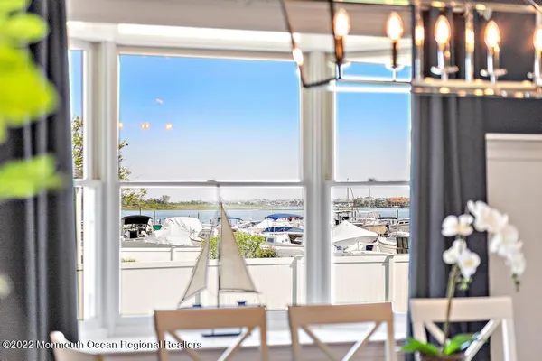 a dining room with furniture and a floor to ceiling window