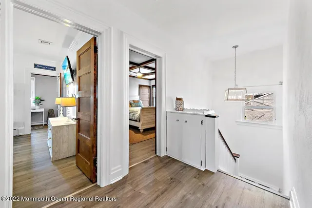 a view of a kitchen with refrigerator and wooden floor
