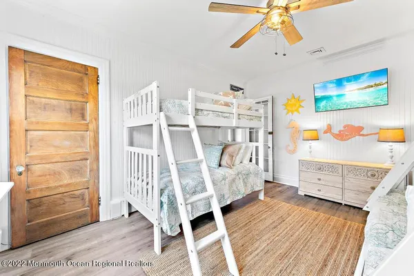 a view of a bedroom with furniture and wooden floor