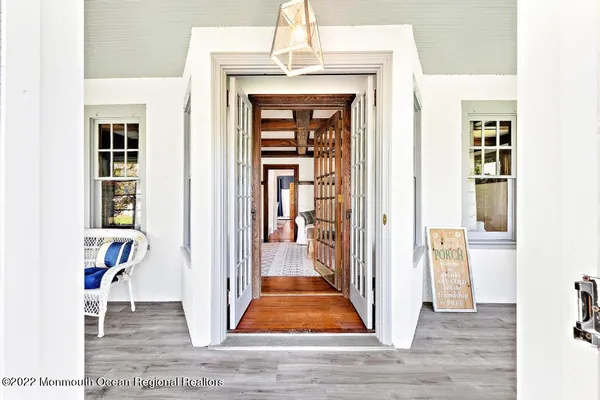a view of a hallway with wooden floor and dining room