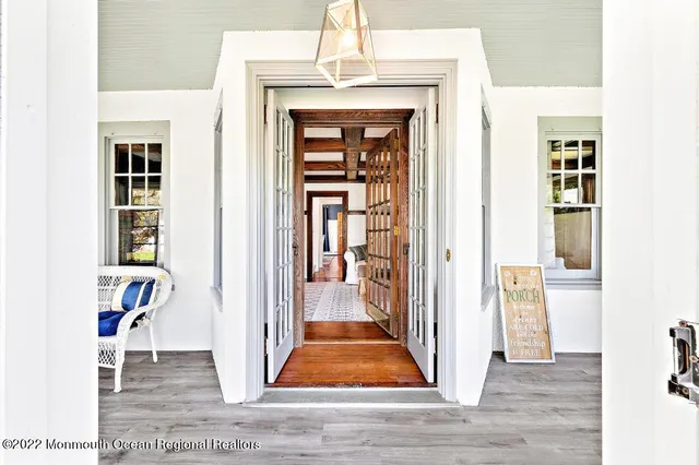 a view of a hallway with wooden floor and dining room