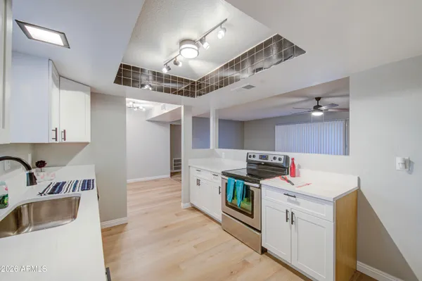 a kitchen that has a lot of cabinets in it and wooden floors