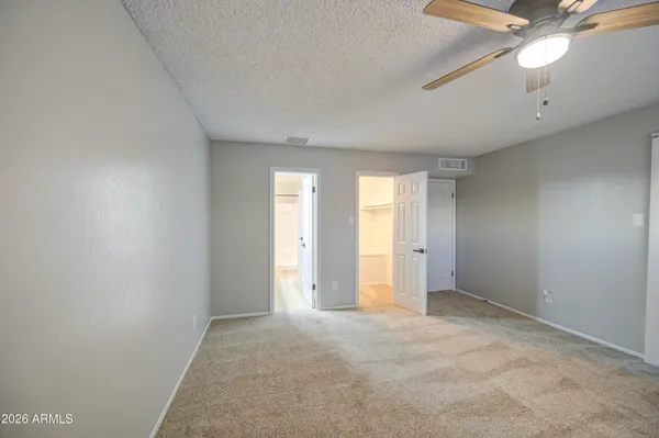an empty room with a ceiling fan and window