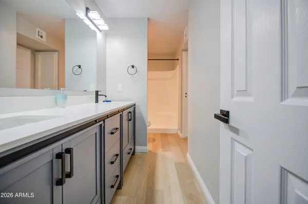 a spacious bathroom with a sink a mirror and a shower
