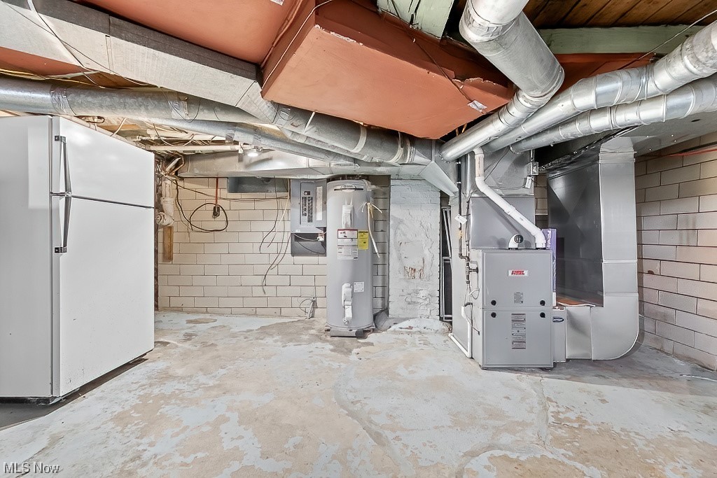 22121 Buck Road Alliance, OH 44601 - Photo 33 of 34 Basement with water heater, white refrigerator, and heating utilities