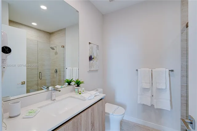 a bathroom with a granite countertop sink a toilet and shower