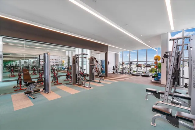 a room with gym equipment and stainless steel appliances
