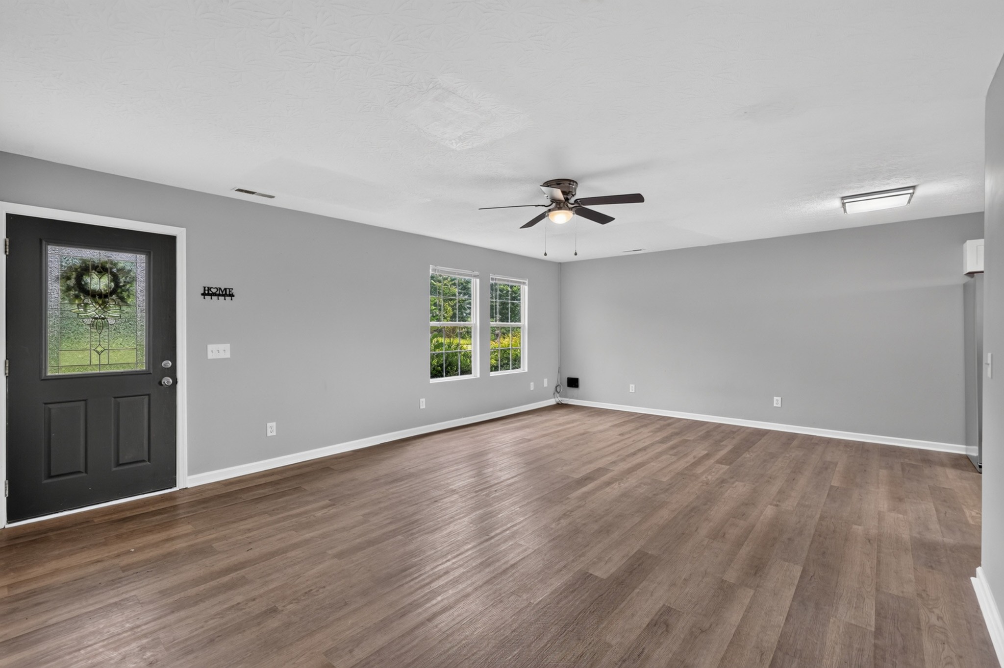 120 Driver Road Lafayette, TN 37083 - Photo 6 of 39 a view of an empty room with wooden floor and a ceiling fan