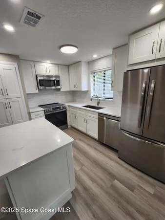 a kitchen with stainless steel appliances a refrigerator sink stove microwave and cabinets